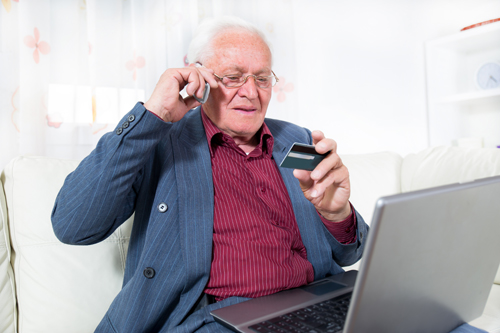 Senior male on his mobile paying for something on his credit card