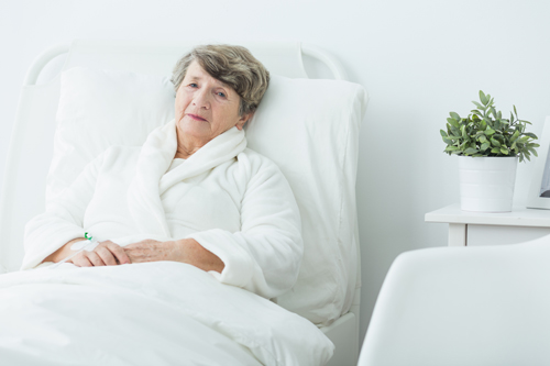 Sick older woman lying in hospital bed