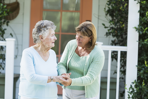 Mature woman (60s) helping elderly mother (90s).