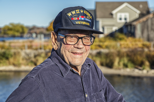 A real person 93 year old senior adult man U.S. Army 2nd Cavalry World War II and Korean Conflict US Air Force military veteran. He's wearing a common, unbranded, generic souvenir shop military veteran commemorative baseball style cap with generic wording, replica plastic insignia pins and replica campaign ribbon iron-on patches.