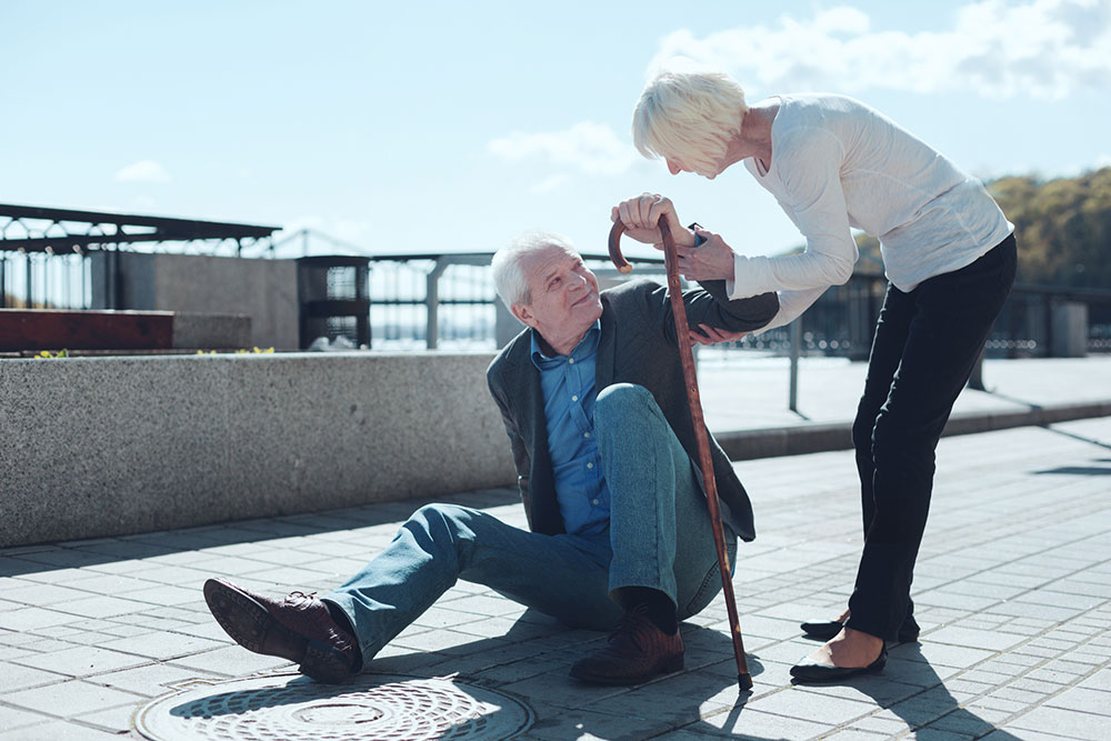 elder woman helping oder man who has fallen