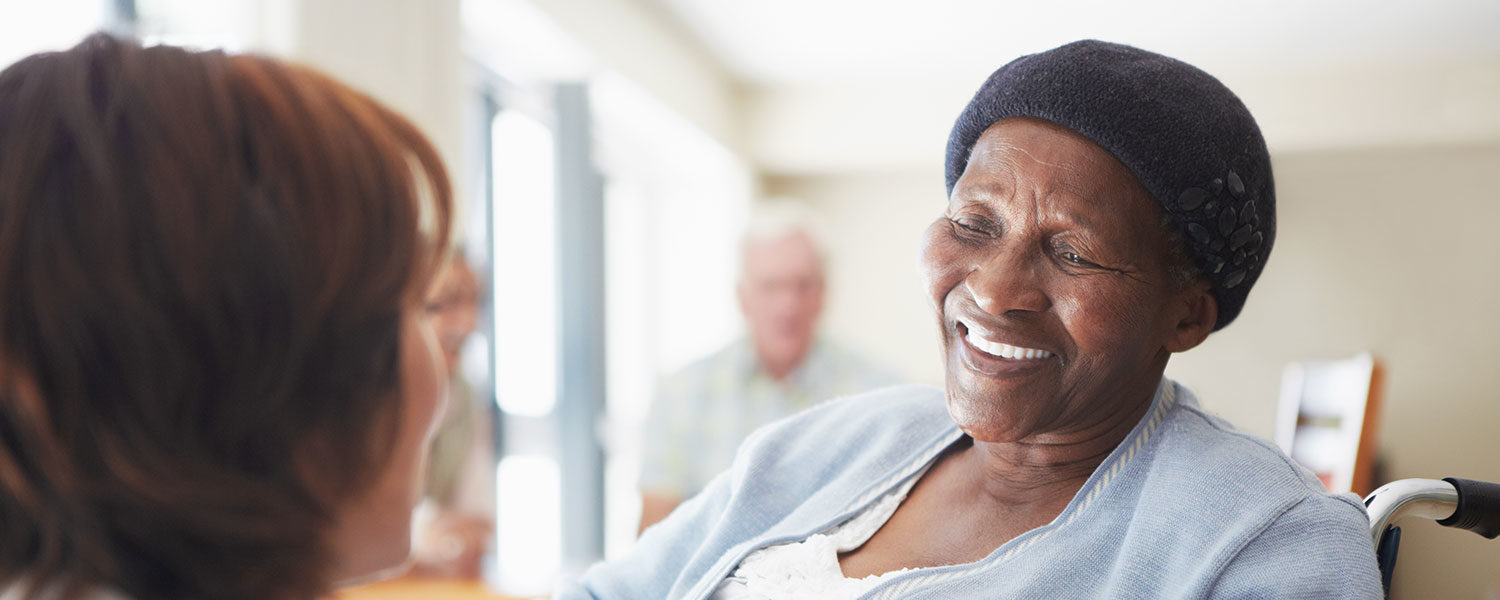 A caregiver talking to a wheelchair-bound patient