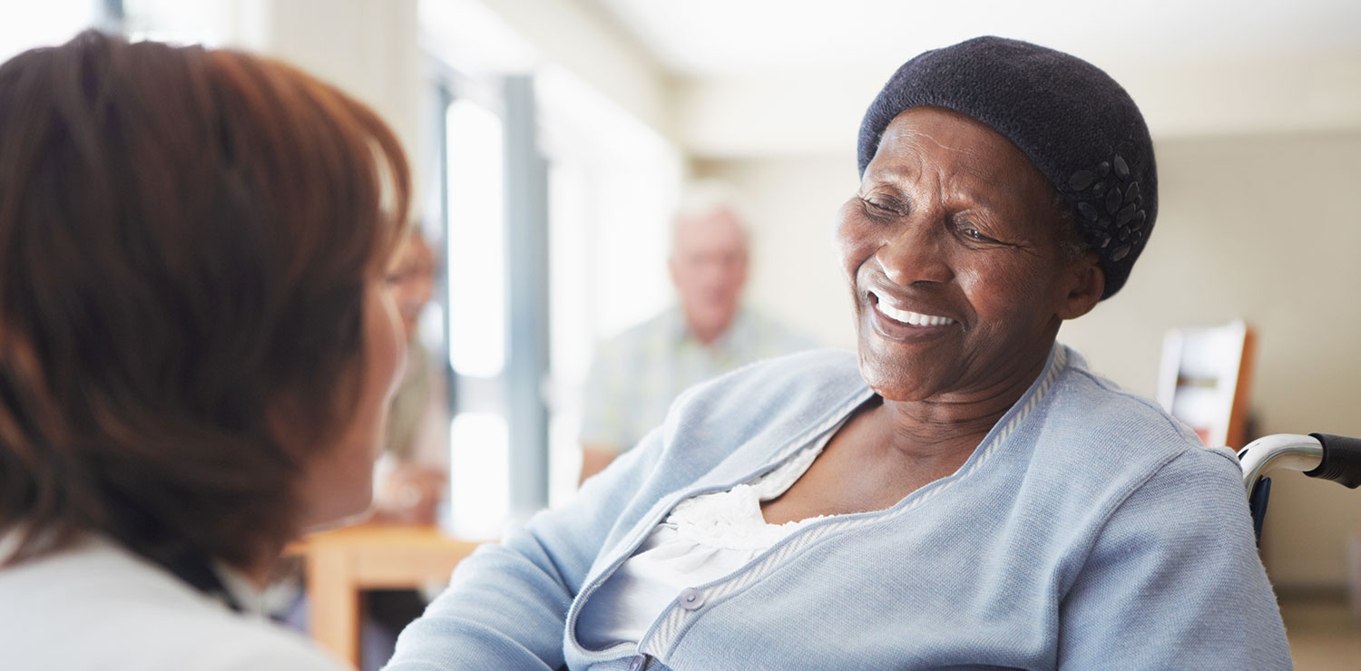 A caregiver talking to a wheelchair-bound patient