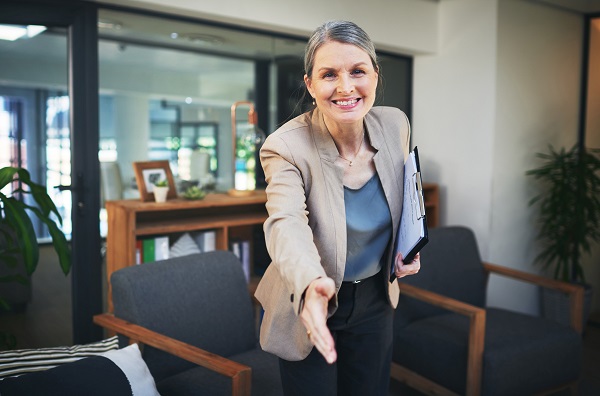 Portrait of a confident mature professional extending her arm for a handshake