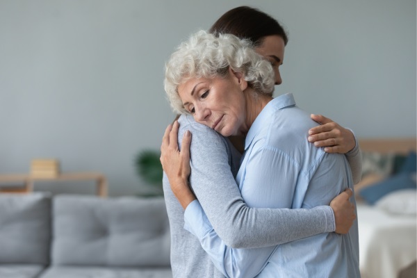 young woman and older woman embracing expressing grief